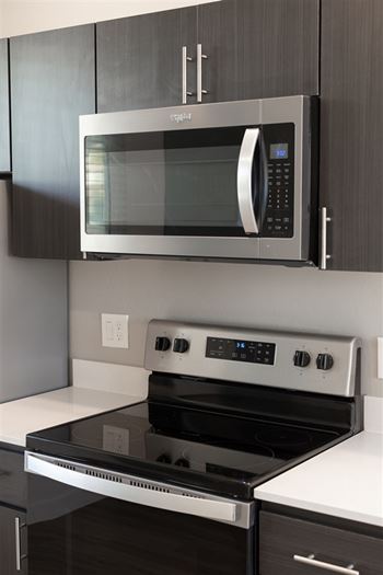 A modern kitchen with a stainless steel microwave and oven.